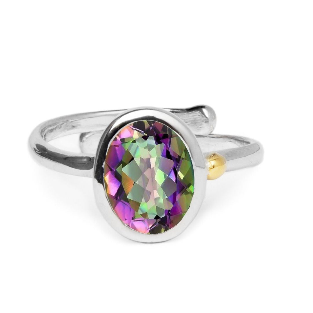 The Adjustable Dream Ring by Gallardo & Blaine Designs showcases a large oval, multicolored gemstone in green, purple, and gold. Crafted in sterling silver with a twisted band and small gold accent, it offers both elegance and minimalist style for versati