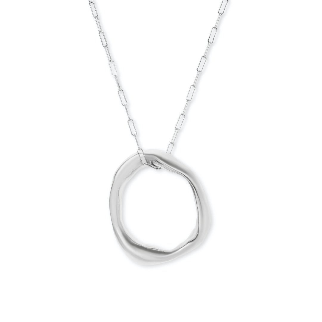The Bough Necklace by Madeleine Blaine features a delicate silver chain and a pendant shaped like an irregular, organic circle. Inspired by Irish oak jewelry and traditional hand-carved techniques, this piece boasts a smooth, polished finish and a modern