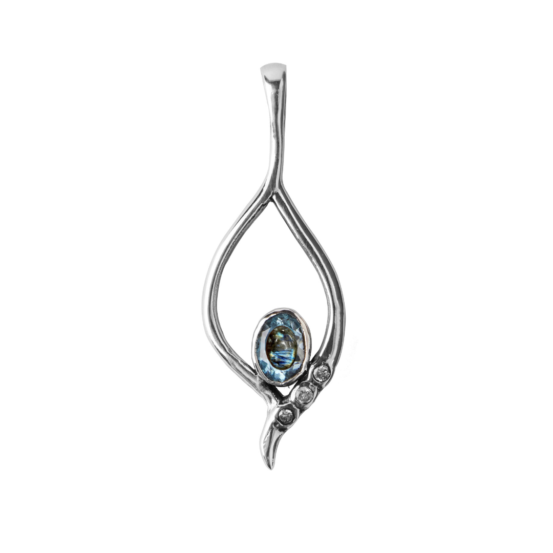 The Desert Star Pendant by Gallardo & Blaine Designs features an open teardrop design set in sterling silver, with an oval blue gemstone at the base and three clear stones arranged diagonally. Available in various gemstones.