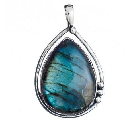The Poppy Pendant Large in various gemstones by Gallardo & Blaine Designs is a teardrop-shaped piece featuring a mesmerizing labradorite gemstone set in polished sterling silver. The labradorite displays iridescent blue and green hues, while the smooth, c