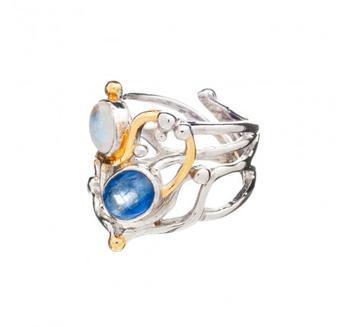 The Seaweed Ring in various gemstones, crafted from sterling silver, showcases an intricate, intertwined design with two prominent gemstones: a larger blue stone set lower and a smaller white stone set higher. Gold vermeil accents highlight parts of the d