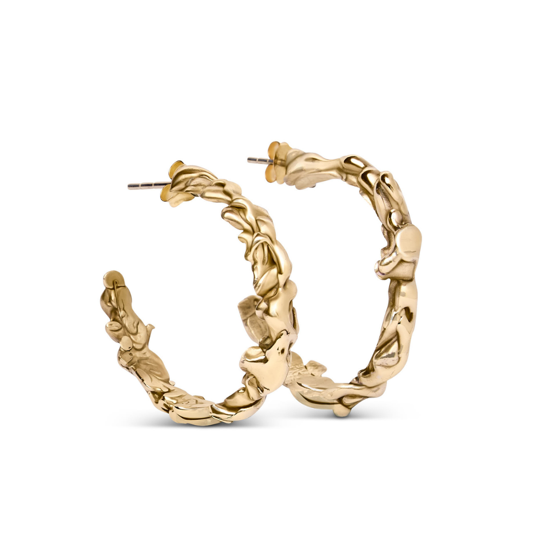 Molten Hoops by Madeleine Sculptural Jewellery: gold hoop earrings with an organic, wavy, hand-carved texture, showcased against a white background. Available in various sizes.