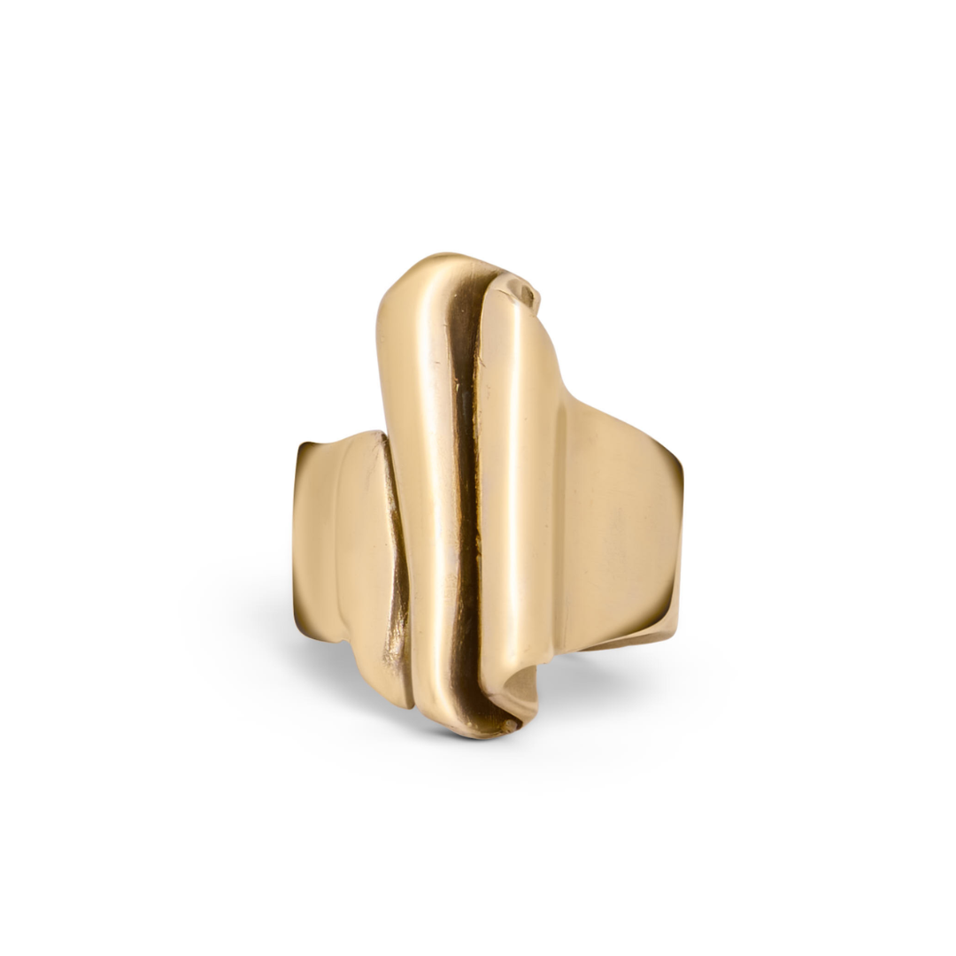 The Tonnach Ring Large by Madeleine Sculptural Jewellery features a bold, abstract design with smooth, overlapping layers and a shiny finish. This hand-carved gold ring is showcased on a white background for a modern look.