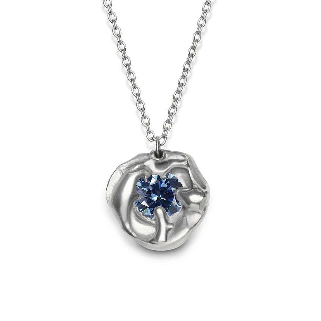 The Molten Necklace with Moissanite by Madeleine Sculptural Jewellery is a handmade piece featuring an abstract organic silver pendant with a round moissanite gemstone at its center, elegantly suspended from a silver chain.