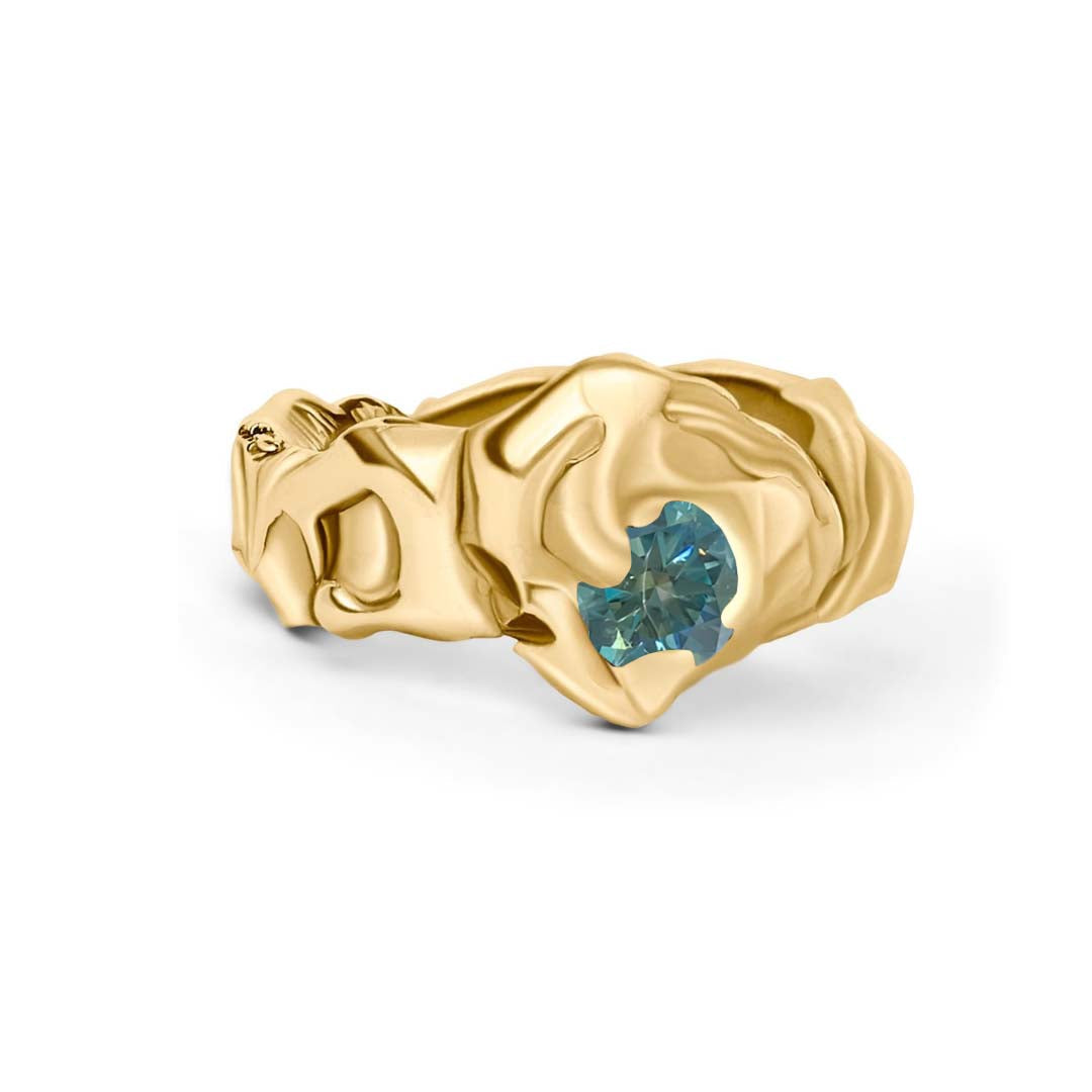 The Molten Ring with Moissanite by Madeleine Sculptural Jewellery features flowing, organic gold shapes and a round moissanite set asymmetrically in the band—a striking, hand-carved statement piece.
