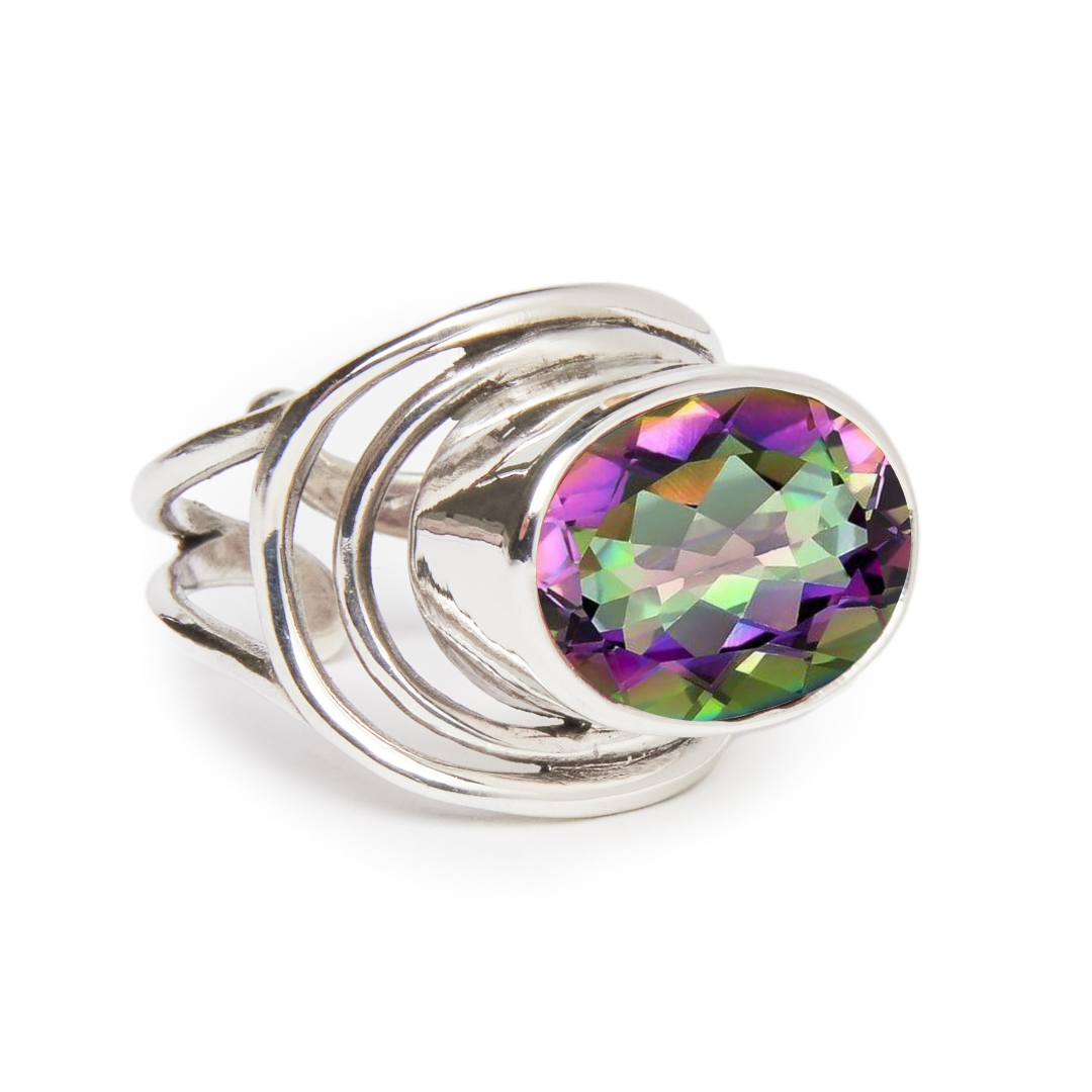 The Party Ring by Gallardo & Blaine Designs showcases a chunky silver band with an overlapping swirl and a large multicolored gemstone at its center, ideal for bold fashion enthusiasts.
