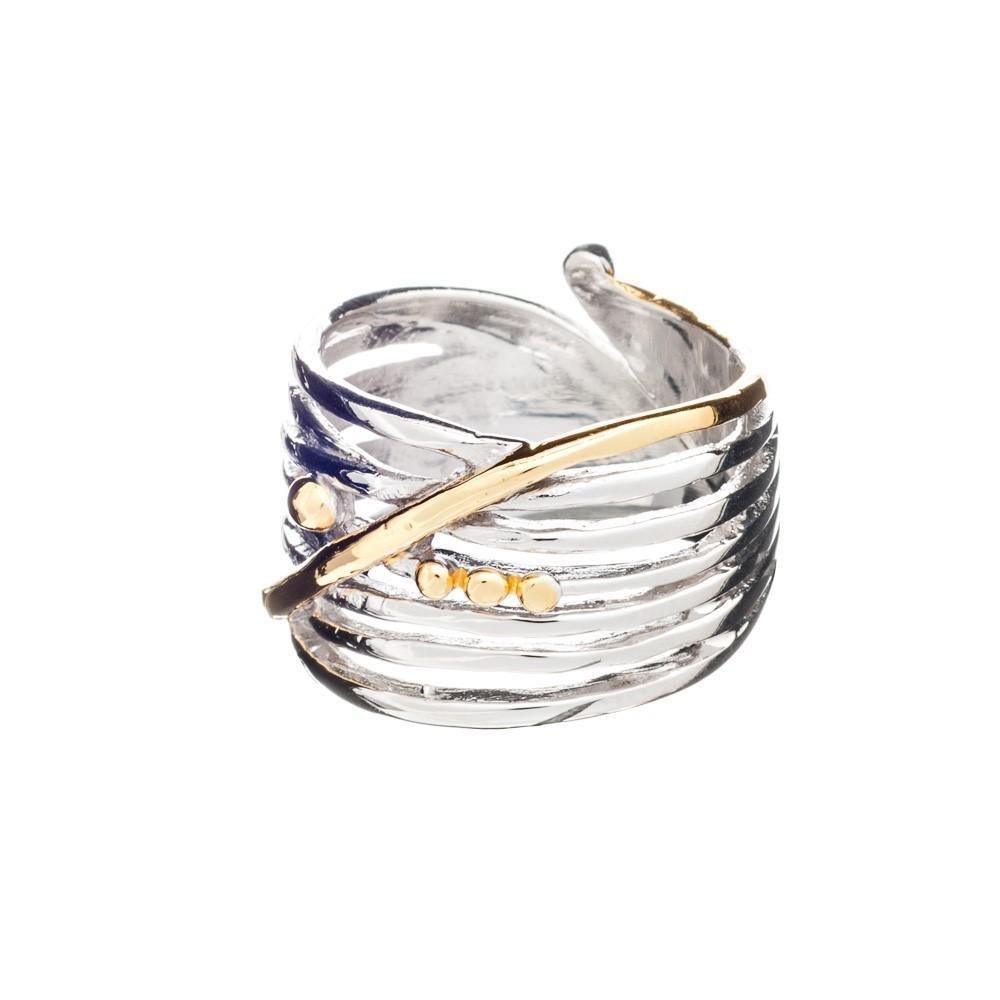 The Bamboo Ring in Sterling Silver & Gold Vermeil by Gallardo & Blaine Designs is a chunky adjustable ring crafted from sterling silver, featuring a layered, textured design with a diagonal gold vermeil band and several small gold dots. This stylish and c