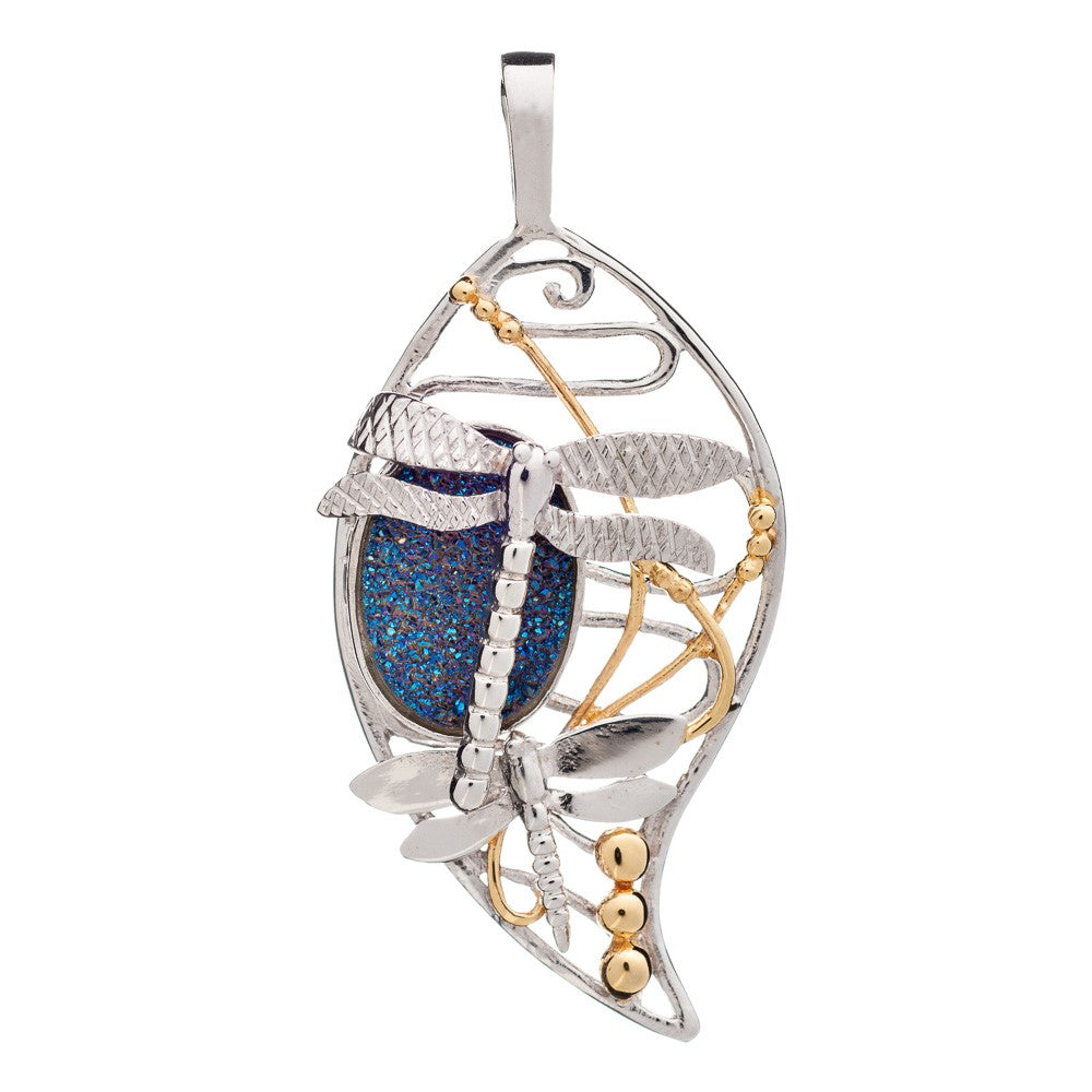 The Bullrush Pendant by Gallardo & Blaine Designs features a dragonfly and leaf motif in silver and gold vermeil, accented with a textured blue oval gemstone—a striking piece of jewelry.