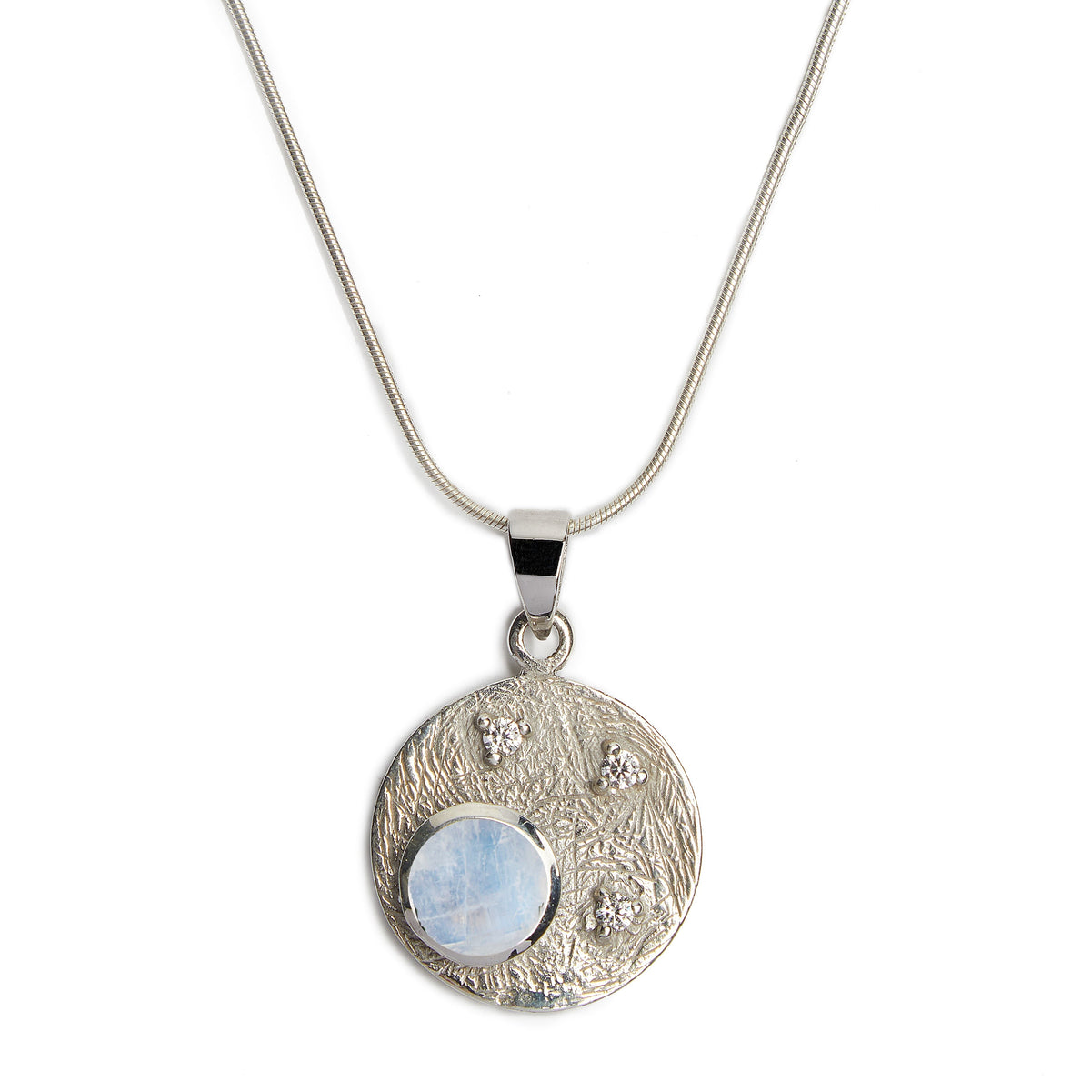 Introducing the Celeste Necklace in Silver & various gemstones by Gallardo & Blaine Designs, a sterling silver pendant necklace featuring a round, textured disc with a polished finish. The disc displays a translucent blue gemstone and three smaller sparkl