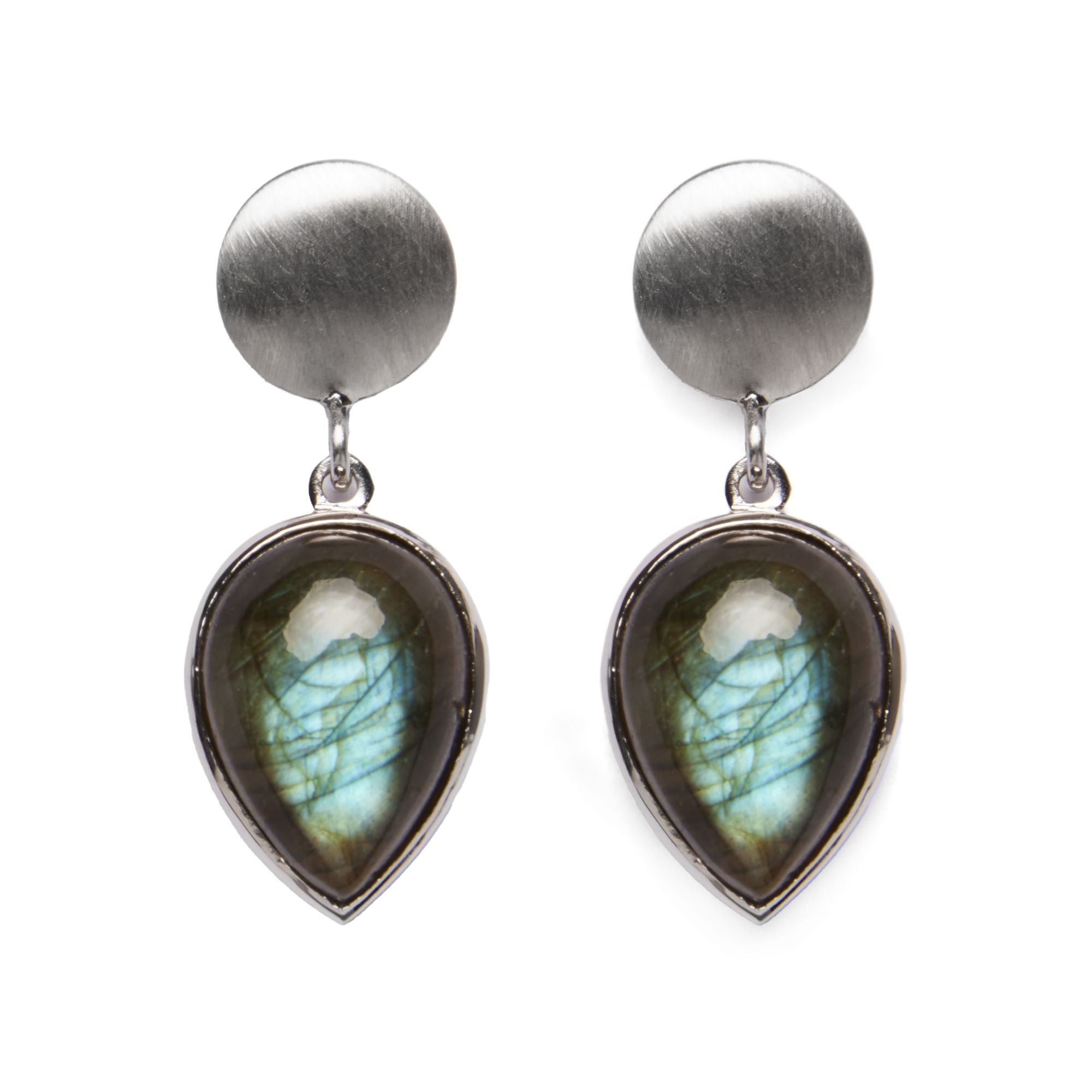 The Daira Earrings by Gallardo & Blaine Designs are a pair of elegant teardrop gemstone earrings featuring a brushed silver circular stud and a labradorite pendant. These colorful gemstones exhibit a play of colors, primarily green and blue, encased in sh