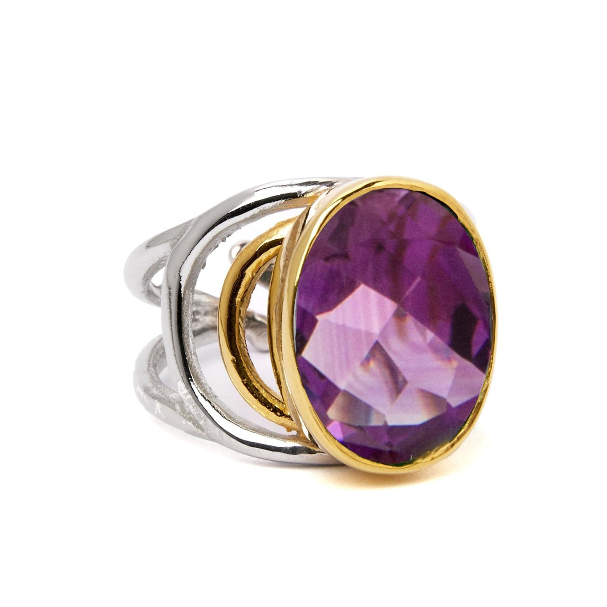The Dewberry Ring by Gallardo & Blaine Designs is a chunky sterling silver statement piece with an open, modern design, showcasing a large faceted oval gemstone set in a gold bezel.