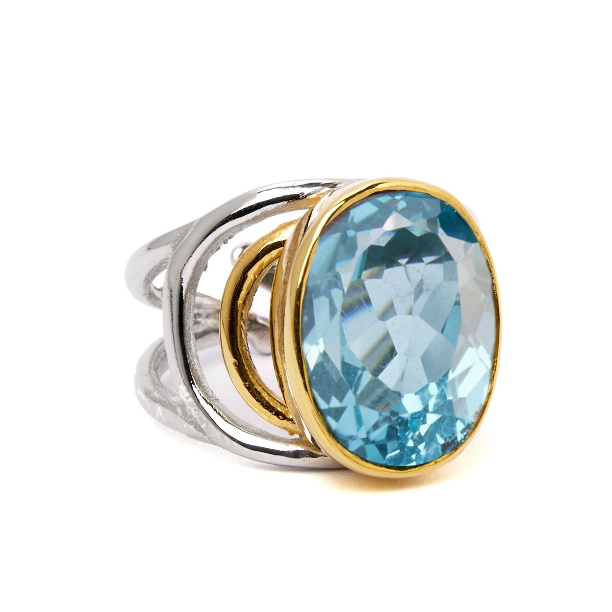 The Gallardo & Blaine Designs Dewberry Ring features an open sterling silver design with a bold oval-cut gemstone in a gold bezel, making it a striking statement piece for any occasion.