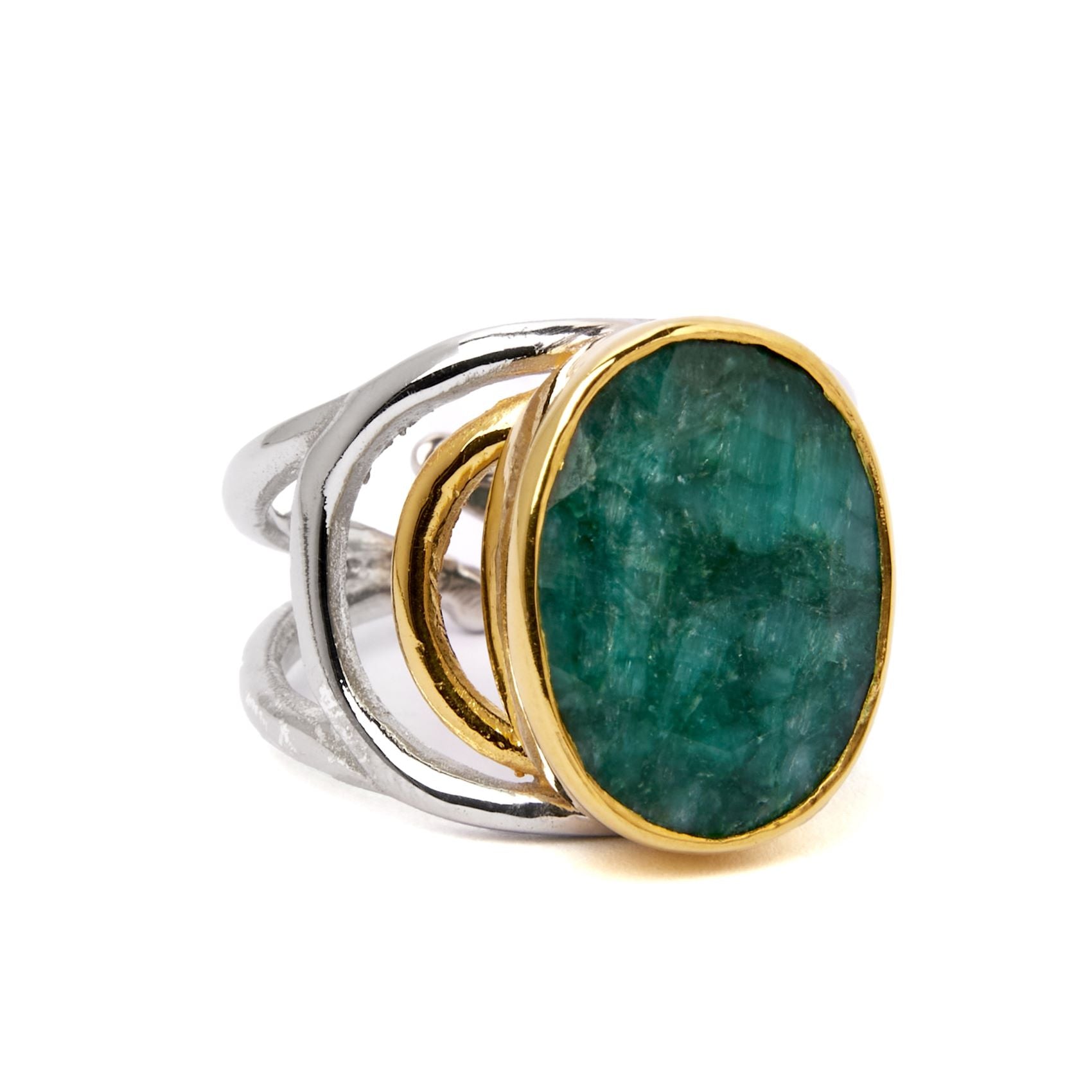 The Dewberry Ring in various gemstones by Gallardo & Blaine Designs is a chunky statement ring featuring a large, oval-shaped emerald with a textured surface, set in a gold bezel. The band is made of sterling silver and has a unique, open design with inte