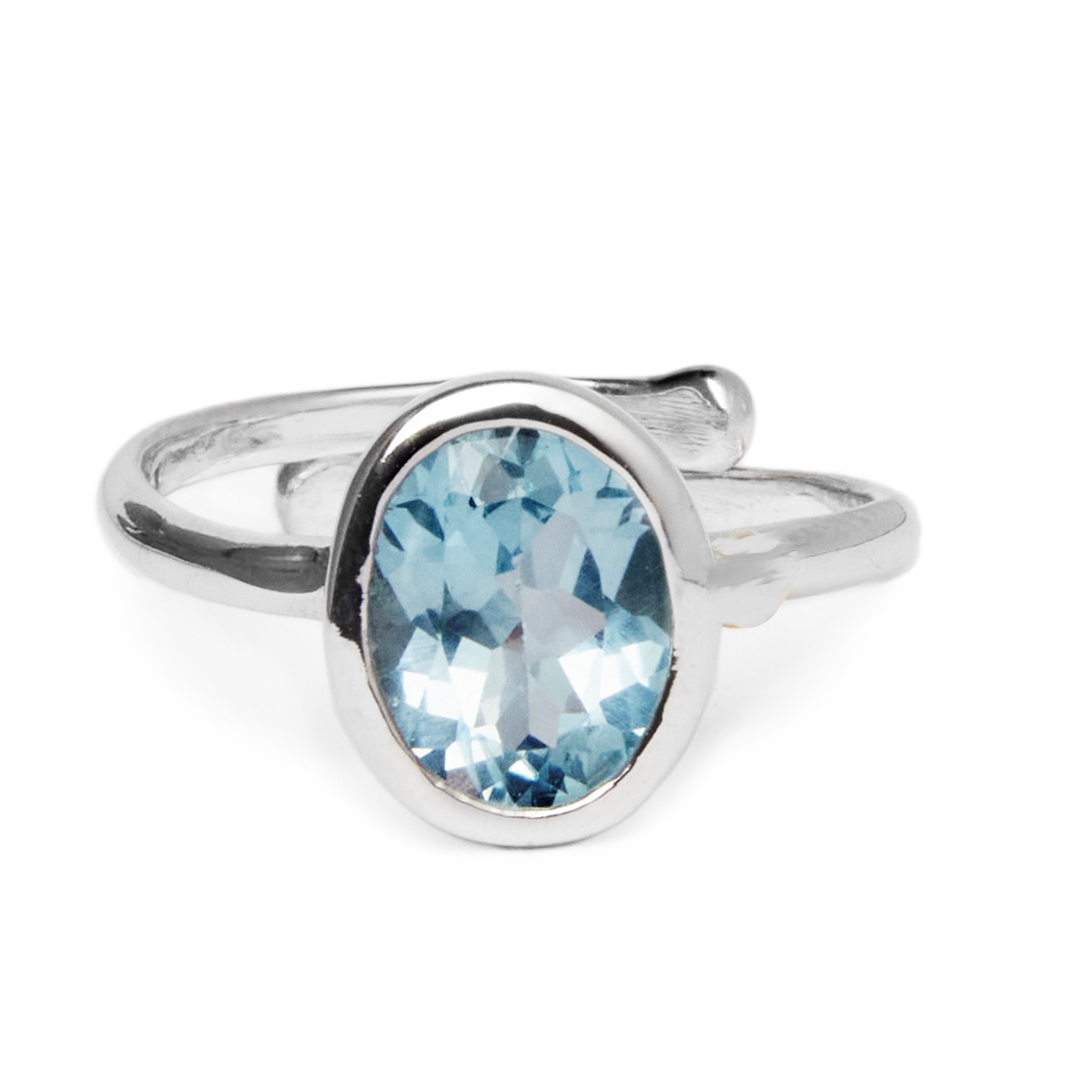 The Dream Ring in various gemstones by Gallardo & Blaine Designs is a sterling silver, adjustable ring featuring an oval-shaped blue gemstone set in a simple band. The gemstone has facets that catch the light, creating subtle highlights and reflections. T