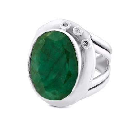 A statement cocktail ring featuring a large, oval-shaped green gemstone as the centerpiece. The gemstone is flanked by two small, round white stones on one side, set within a polished and sleek silver band with a split shank design. This adjustable design