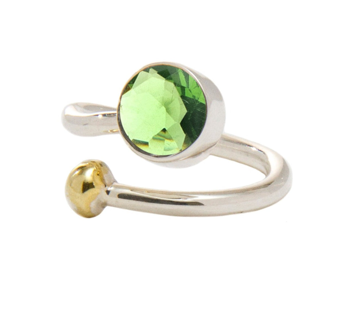 A shiny, open-ended silver and gold jewelry piece features a round, faceted green gem on one end and a small gold ball on the other. This elegant Honeysuckle Ring in Silver Gold & gemstones by Gallardo & Blaine Designs' minimalist design highlights the vi