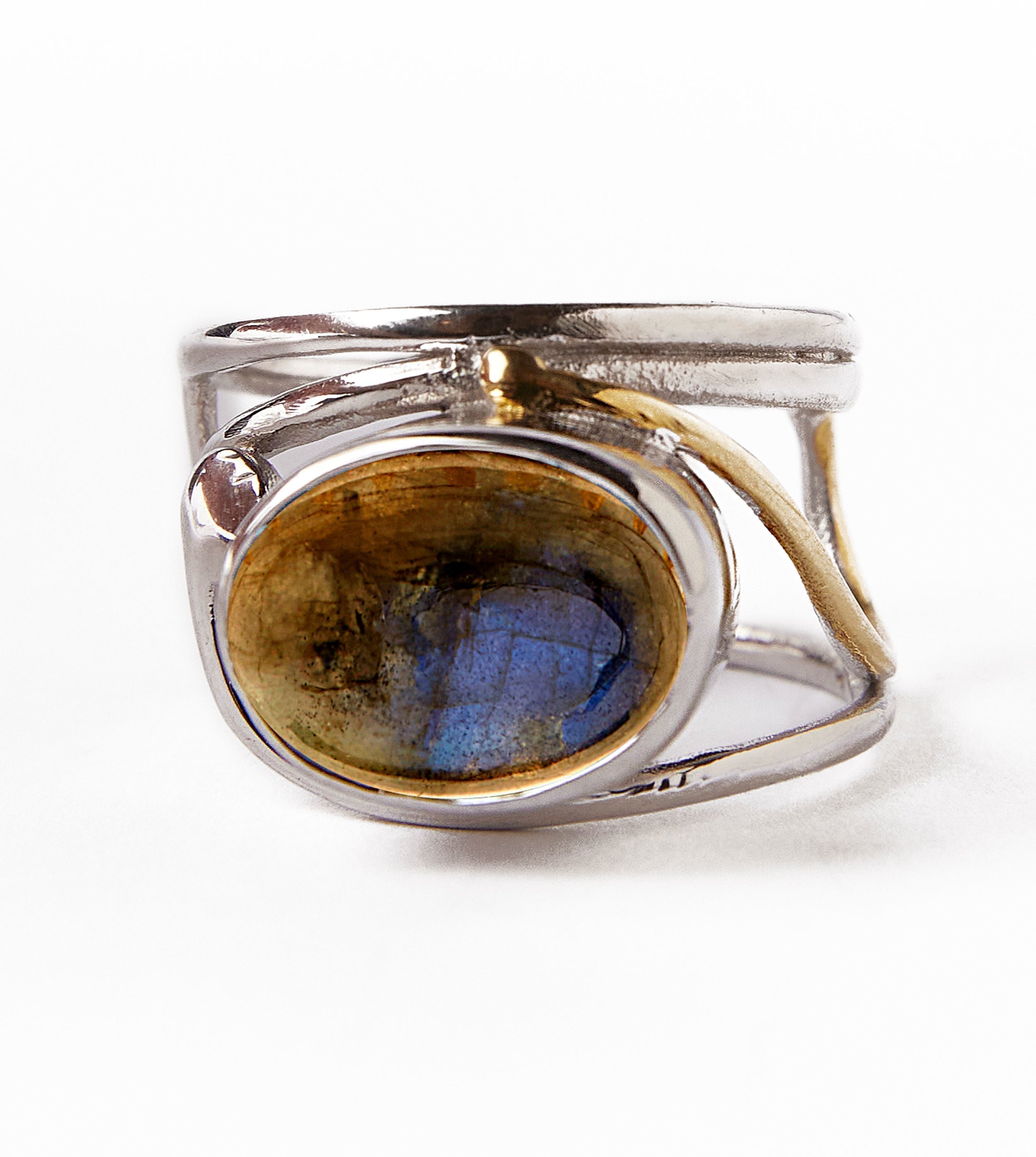The Gallardo & Blaine Designs Horizontal Ring boasts an intricate silver and gold-plated band design with an oval labradorite gemstone. The stone's deep blue and brown hues are highlighted against a white background, showcasing the ring's detailed craftsm