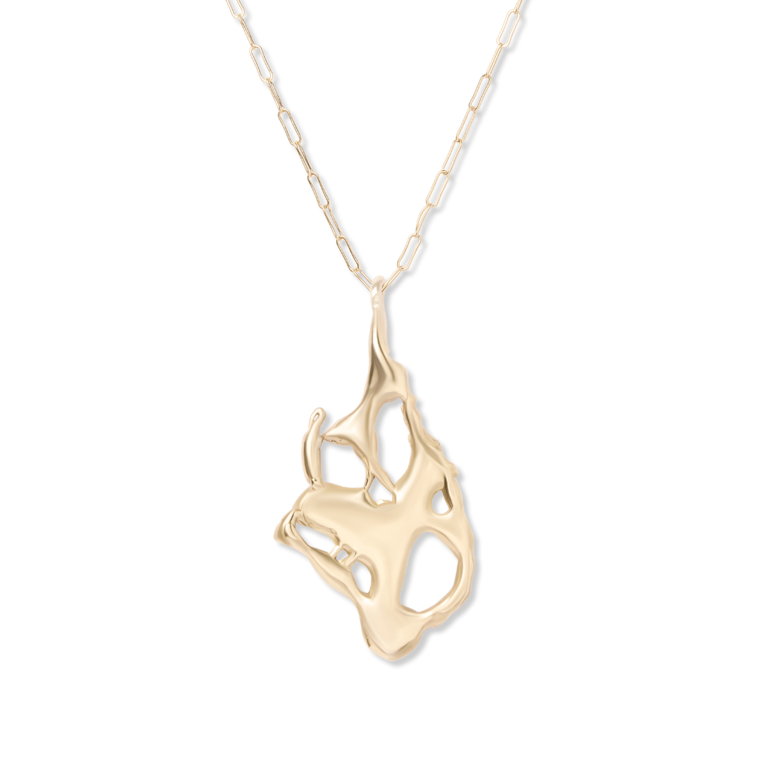 The Molten Necklace by Madeleine Sculptural Jewellery features a thin gold chain and a large, abstract pendant with open cutouts and smooth, flowing edges—an elegant handmade piece.