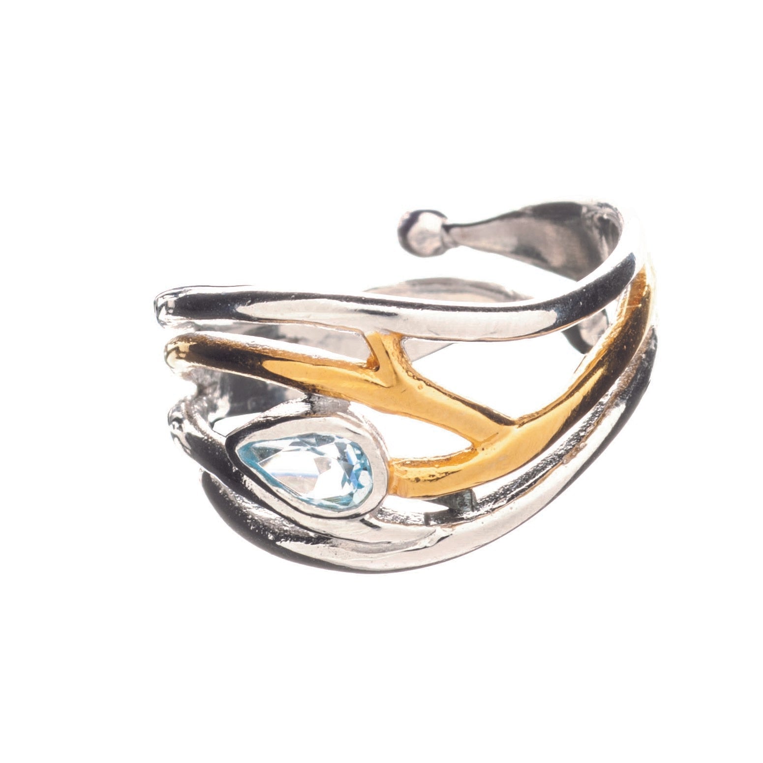 A silver and gold-toned Peacock Ring with an open design, featuring overlapping curves and branches. This elegant dainty ring showcases a teardrop-shaped blue gemstone set into one of the curves. The background is white, highlighting the ring's intricate