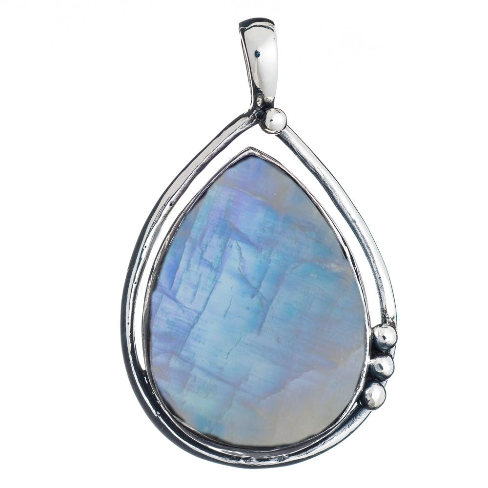 The Poppy Pendant Large in various gemstones by Gallardo & Blaine Designs showcases a teardrop-shaped, iridescent blue and purple labradorite gemstone, elegantly encased in a sterling silver frame with a small silver ball detail on one side. The pendant f