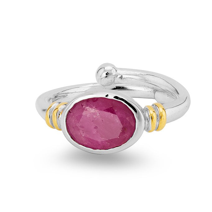 A silver Art Nouveau ring with a polished, oval-shaped pink gemstone in the center. The band features two small gold accents on each side of the stone, adding a touch of contrast to the design. This Senna Ring in various gemstones by Gallardo & Blaine Des