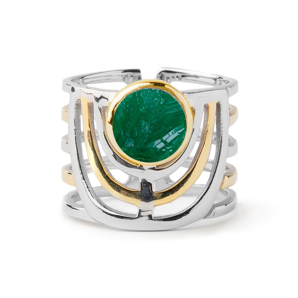 A bold jewellery design, the Solar Ring in various gemstones by Gallardo & Blaine Designs features an open band with a round, green gemstone in the center, surrounded by a gold bezel setting. The band splits into multiple parallel sections, creating an in