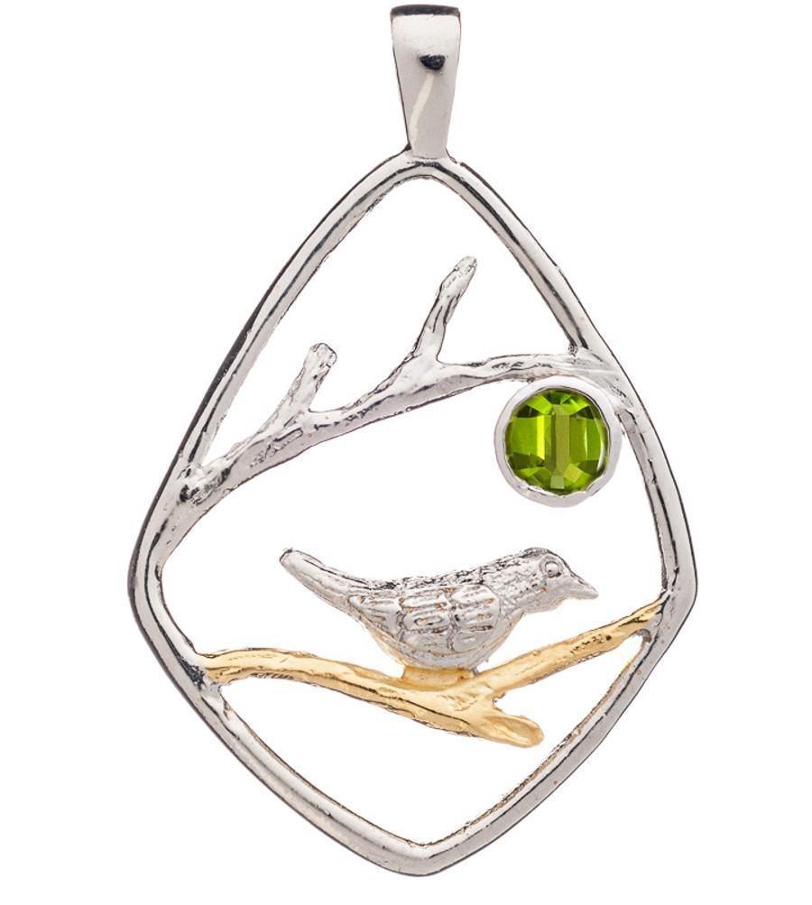 An elegant Song Bird Pendant by Gallardo & Blaine Designs featuring a song bird perched on a golden branch within a diamond-shaped sterling silver frame. A green gemstone is set inside, depicting a sun or moon. Delicate branches extend across the design,