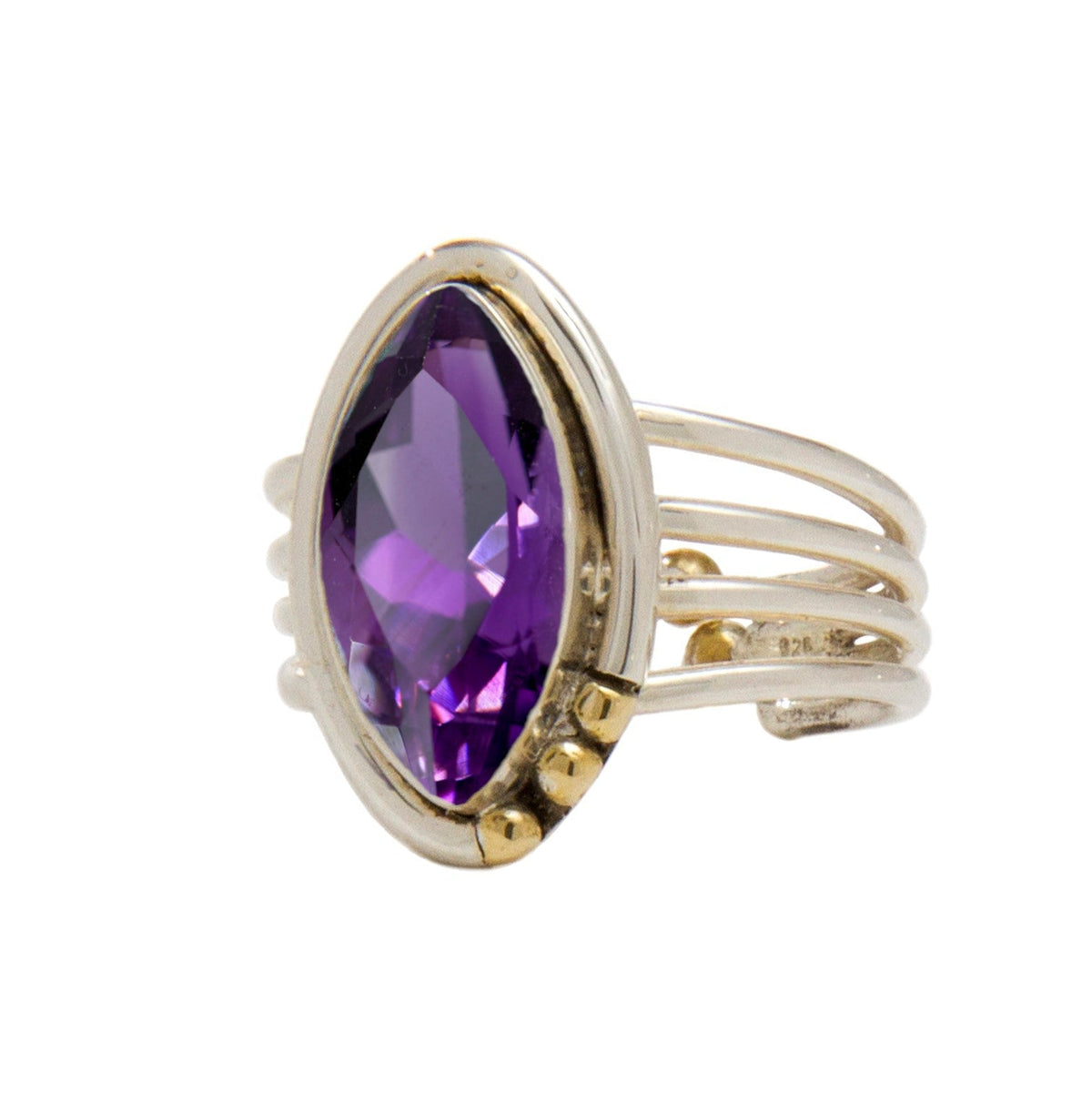 A gold Tulip Ring in various gemstones by Gallardo & Blaine Designs featuring a large, marquise-cut purple gemstone as its centerpiece. The band splits into four parallel strands, connecting to the stone with small gold accents on one side, adding an intr