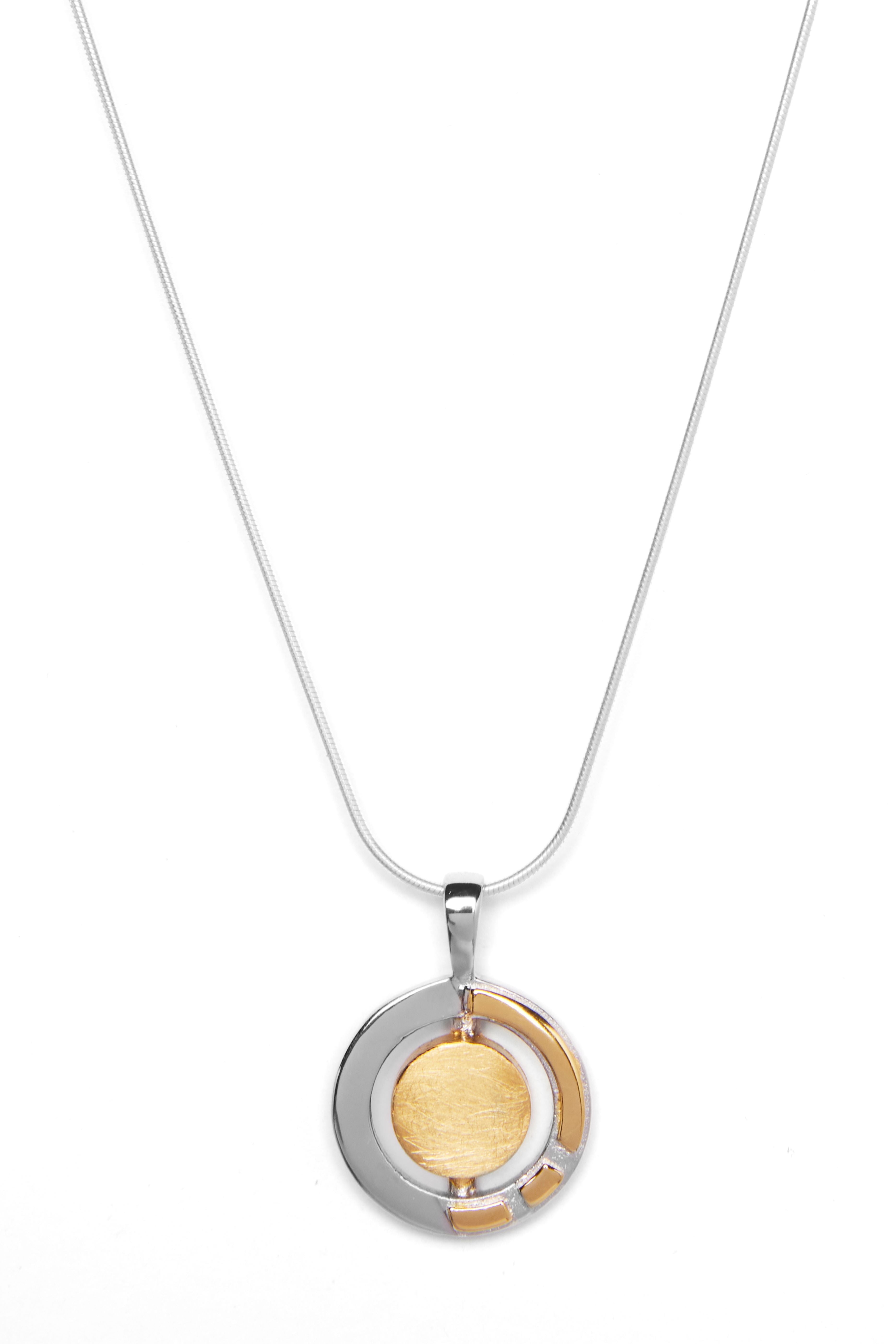 A silver necklace featuring a round, dual-tone Urú Small Pendant & Chain by Gallardo & Blaine Designs. The pendant has concentric circles, with an inner gold-colored circle surrounded by a partial silver ring. The thin, elegant sterling silver chain comp