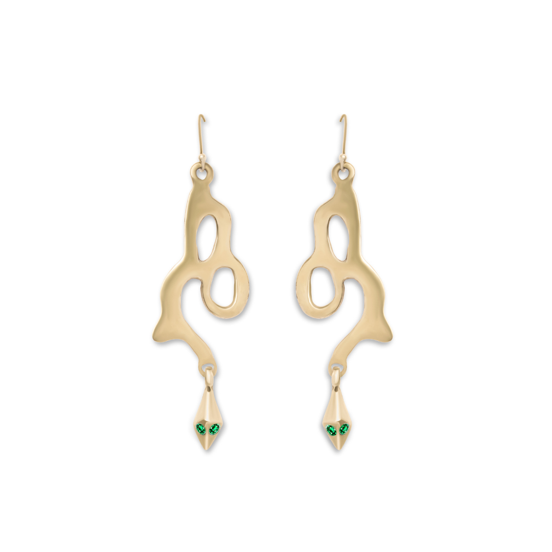 Introducing the Serpent Earrings by Madeleine Blaine—handcrafted gold earrings featuring abstract, wavy curves and snakehead-inspired dangles adorned with small green gemstone eyes. Displayed against a crisp white background, these contemporary pieces ble