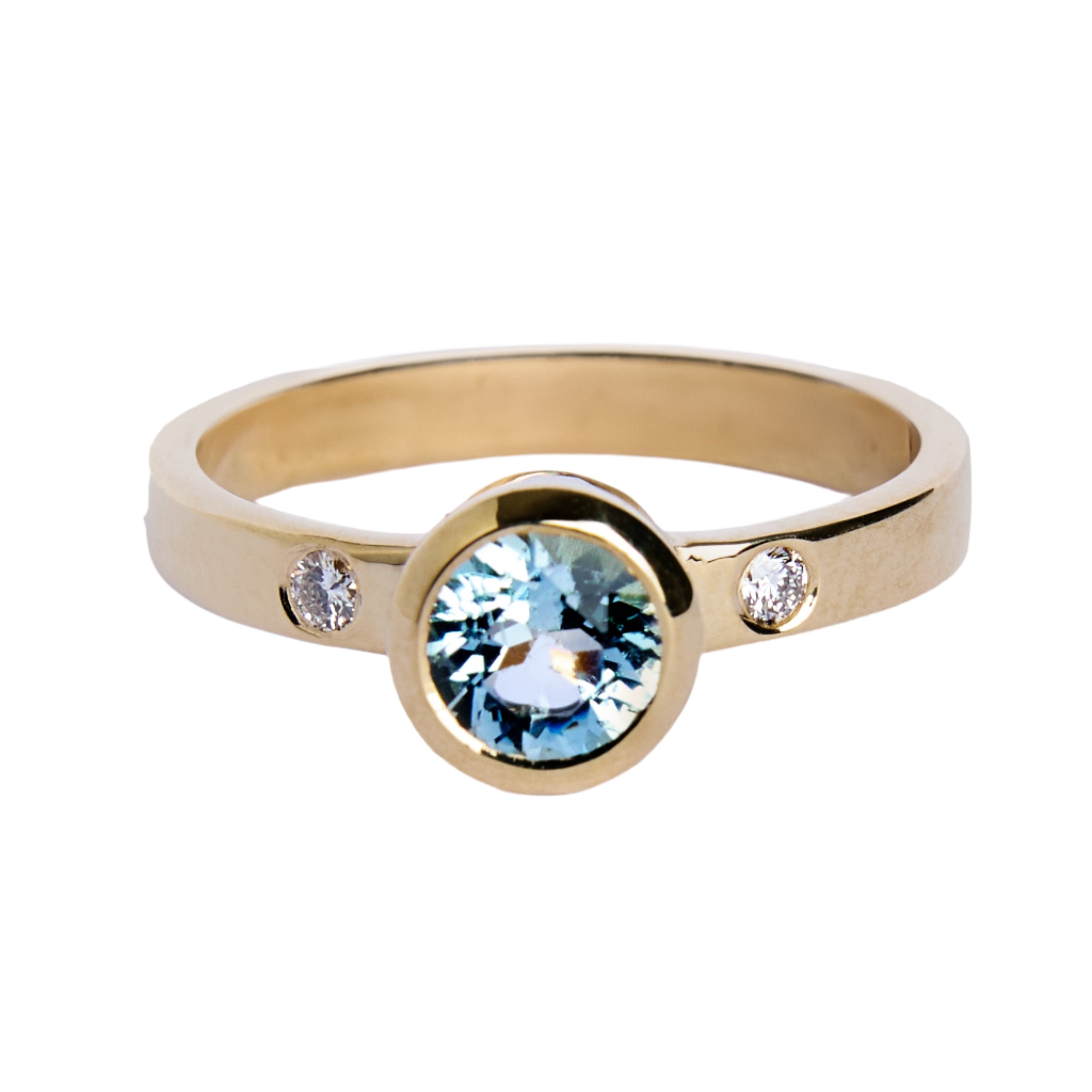 The Timeless Cascade 9ct Yellow Ring by Madeleine Fine Jewellery showcases a large round aquamarine center stone, accented by two small lab-grown diamonds set into the band.