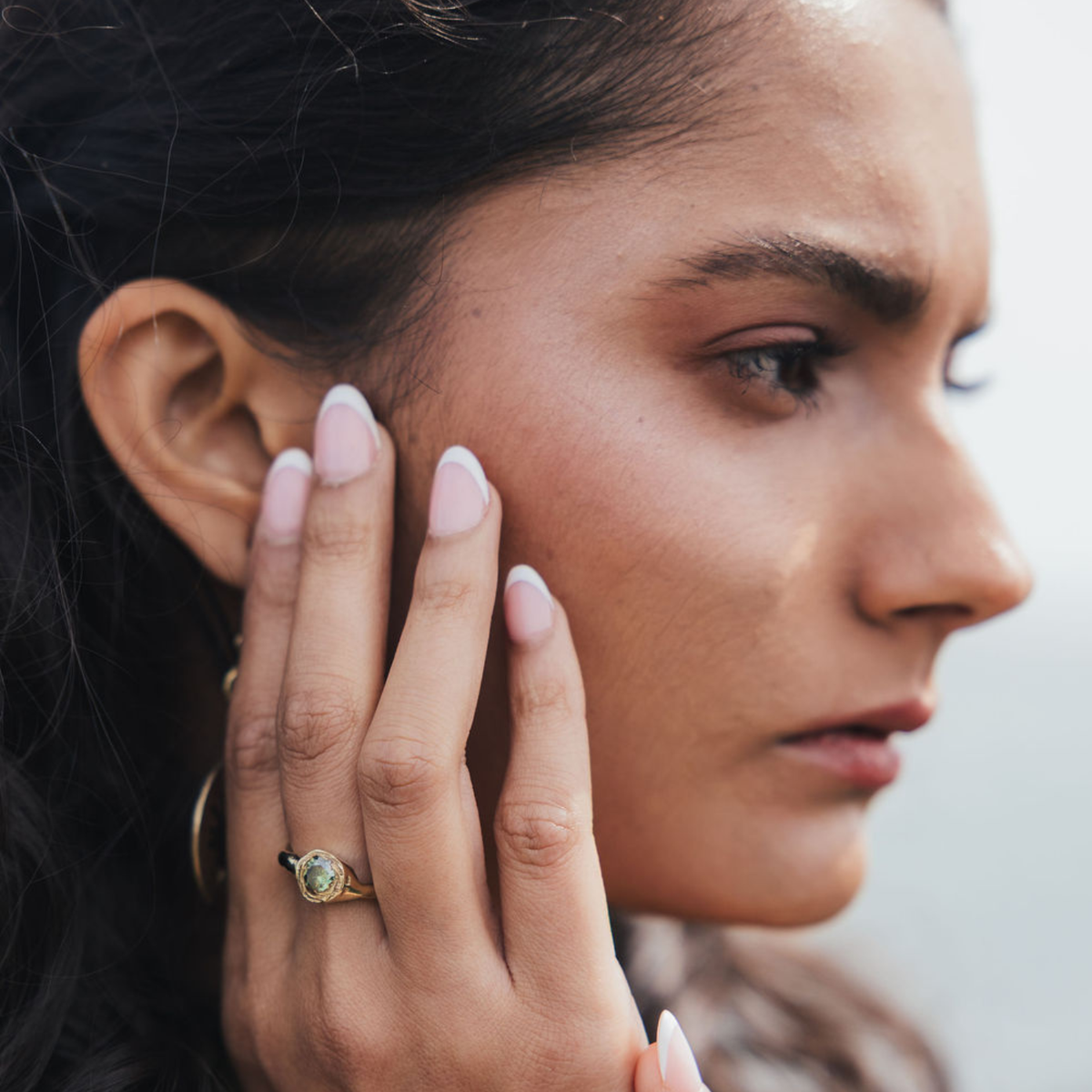 Delicate gold ring with minimalist design inspired by dawn sky aesthetics, shown on hand against soft background.
