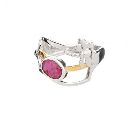 A unique silver & gold plate ring featuring an asymmetrical band design with a contrasting gold accent. At the center of this adjustable ring is a prominent, round pink gemstone held in place by an intricate metal setting. The overall design is modern and