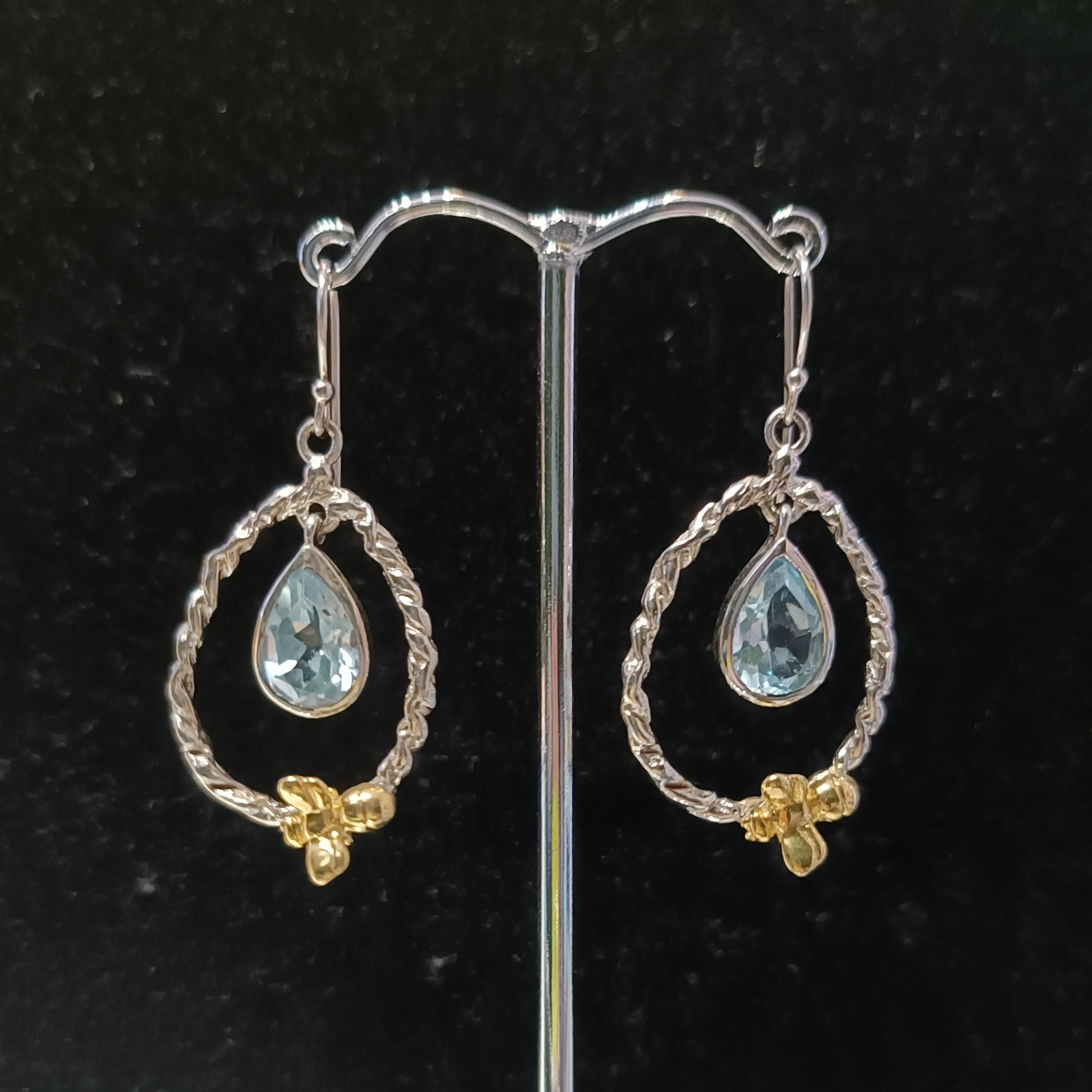The Watermelon Tropical Wildlife Small Bee Hoop Drops feature twisted silver hoops with teardrop-shaped gemstones and small gold accents, shown against a black background.