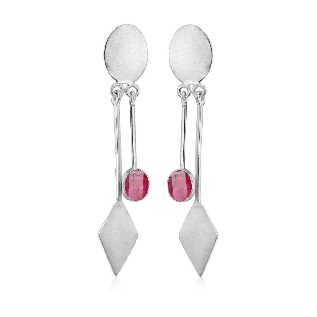 Discover the Karo Earrings by Gallardo & Blaine Designs, where modern elegance meets unique design. These silver dangle drops feature oval tops, rectangular bars with centrally set small round red gemstones, and diamond-shaped bottom pieces. Available in 