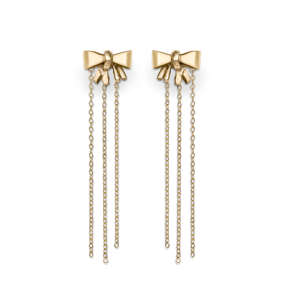 Hand-carved Bow earrings by Madeleine Blaine, crafted from gold-plated brass and shaped like elegant bows, feature three delicate chain strands hanging from each bow to highlight exquisite artistry, beautifully displayed on a white background.