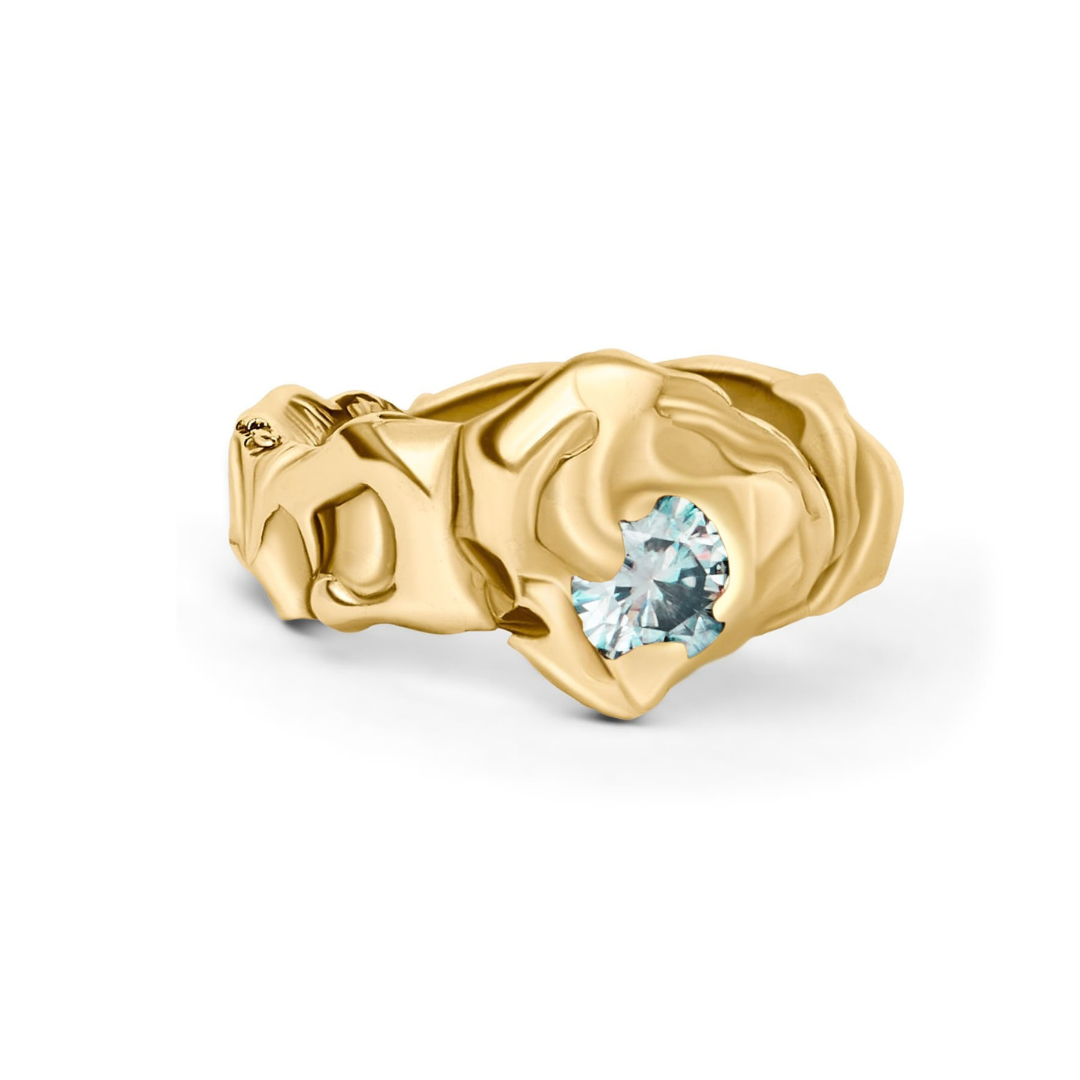 The Molten Ring with Moissanite by Madeleine Sculptural Jewellery features an organic gold design with a single round moissanite nestled in sculpted folds—a standout piece of sustainable jewellery.