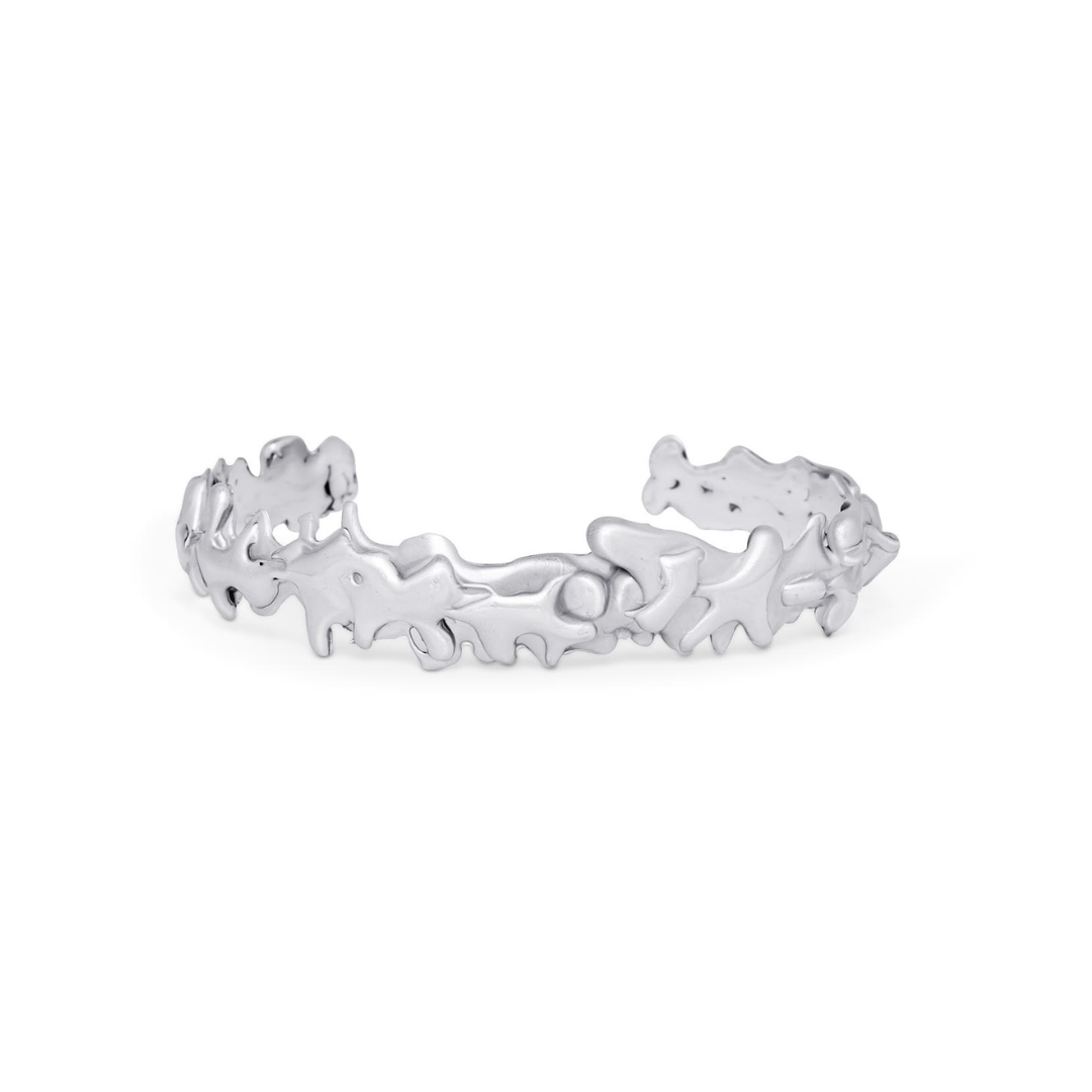 The Molten Cuff Small by Madeleine Sculptural Jewellery features an abstract, organic design with irregular, flowing shapes and a slightly open gap, showcasing the artistry of hand-carved silver jewellery.