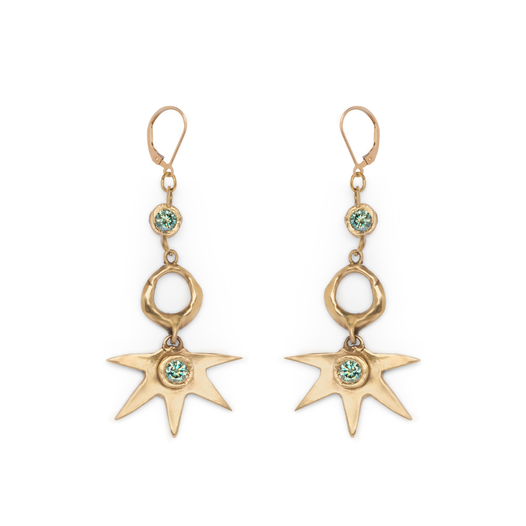 Discover the Réalta Earrings with 2 moissanite by Madeleine Sculptural Jewellery—gold dangle earrings featuring a radiant sunburst motif accented with blue-green gemstones. Each earring showcases a three-part arrangement of circular and star-shaped charms