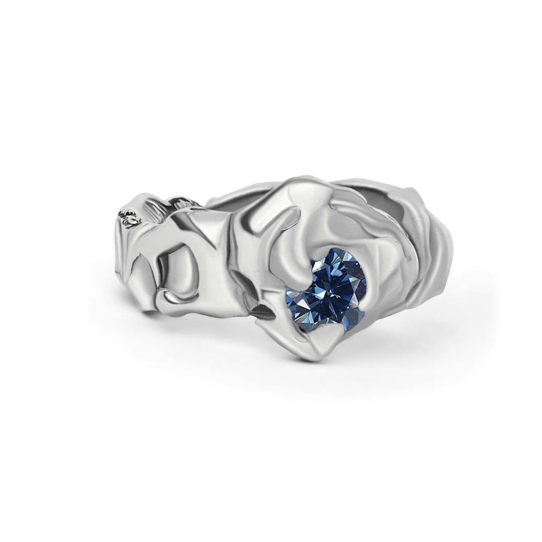 The Molten Ring with Moissanite by Madeleine Sculptural Jewellery is a hand-carved silver ring with an abstract, organic design, featuring a single round moissanite gemstone—a striking piece of sustainable jewellery.