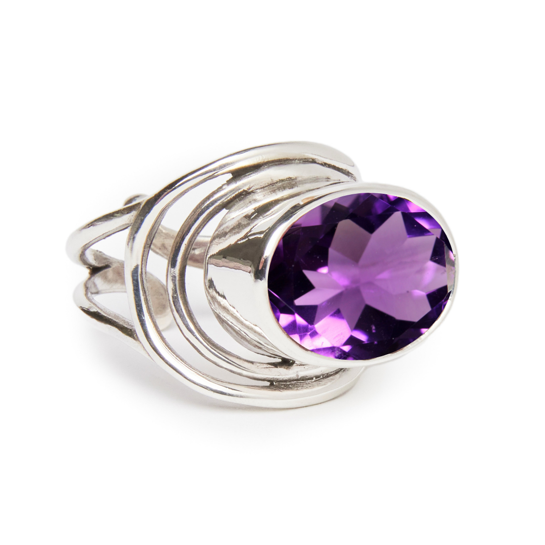 Gallardo & Blaine Designs' Party Ring showcases a large, faceted purple gemstone in a swirl setting, ideal for making a chunky statement.
