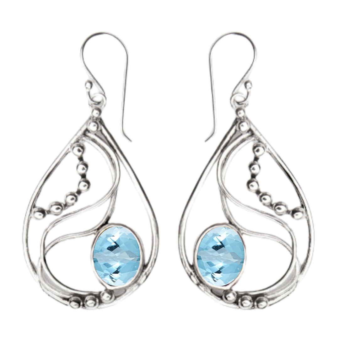 The Phoenix Earrings by Gallardo & Blaine Designs feature teardrop-shaped sterling silver with swirling patterns, small silver beads, and an oval-cut light blue gemstone at the bottom center.