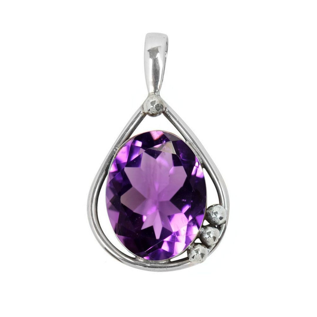 The Poppy Pendant Small by Gallardo & Blaine Designs features a teardrop sterling silver and gold setting with a faceted purple gemstone center, accented by three small silver beads on one side.