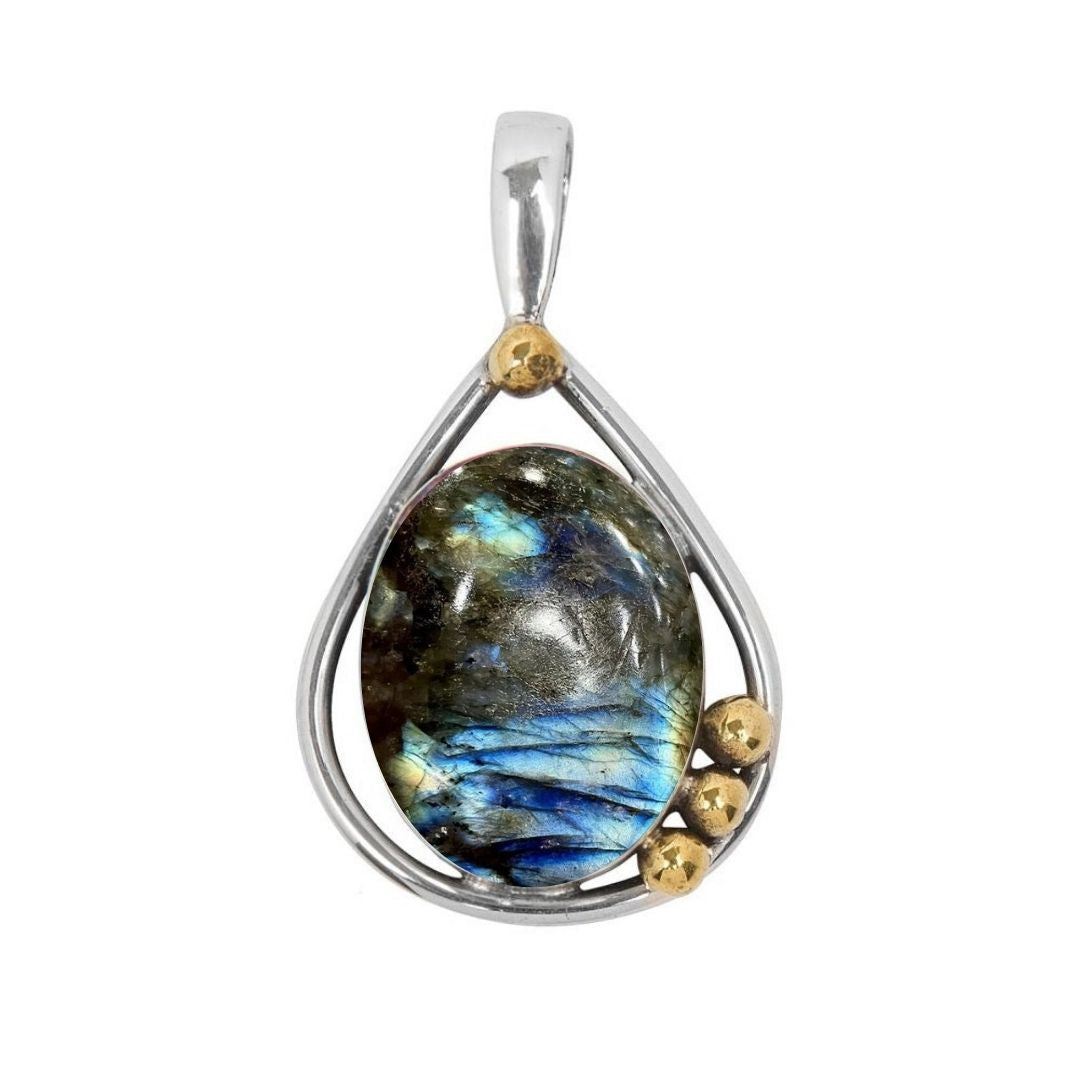 The Poppy Pendant Small by Gallardo & Blaine Designs features an oval labradorite gemstone with blue-green iridescence, set in a sterling silver and gold frame with three gold accents at the bottom right.