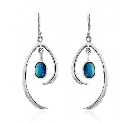 A pair of Primrose Earrings in various gemstones from Gallardo & Blaine Designs, in sterling silver with an artistic, curved design, each featuring an oval-shaped blue gemstone. The gemstones are suspended in the middle of the curved silver elements, prov
