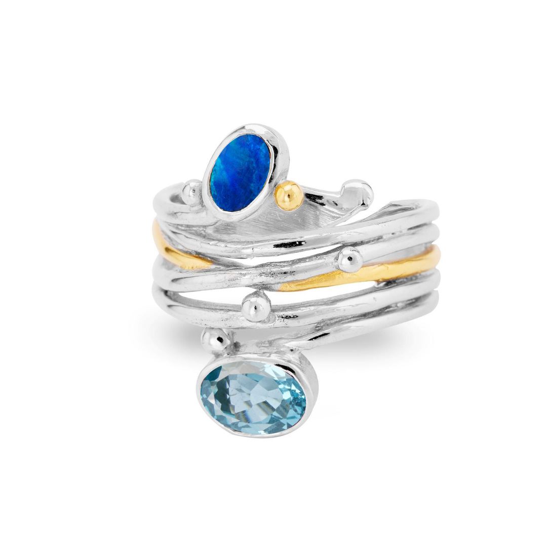 The Gallardo & Blaine Designs Snake Ring in Silver Gold features multiple interwoven bands, gold accents, a blue opal stone on top, and a larger oval blue gemstone at the base.