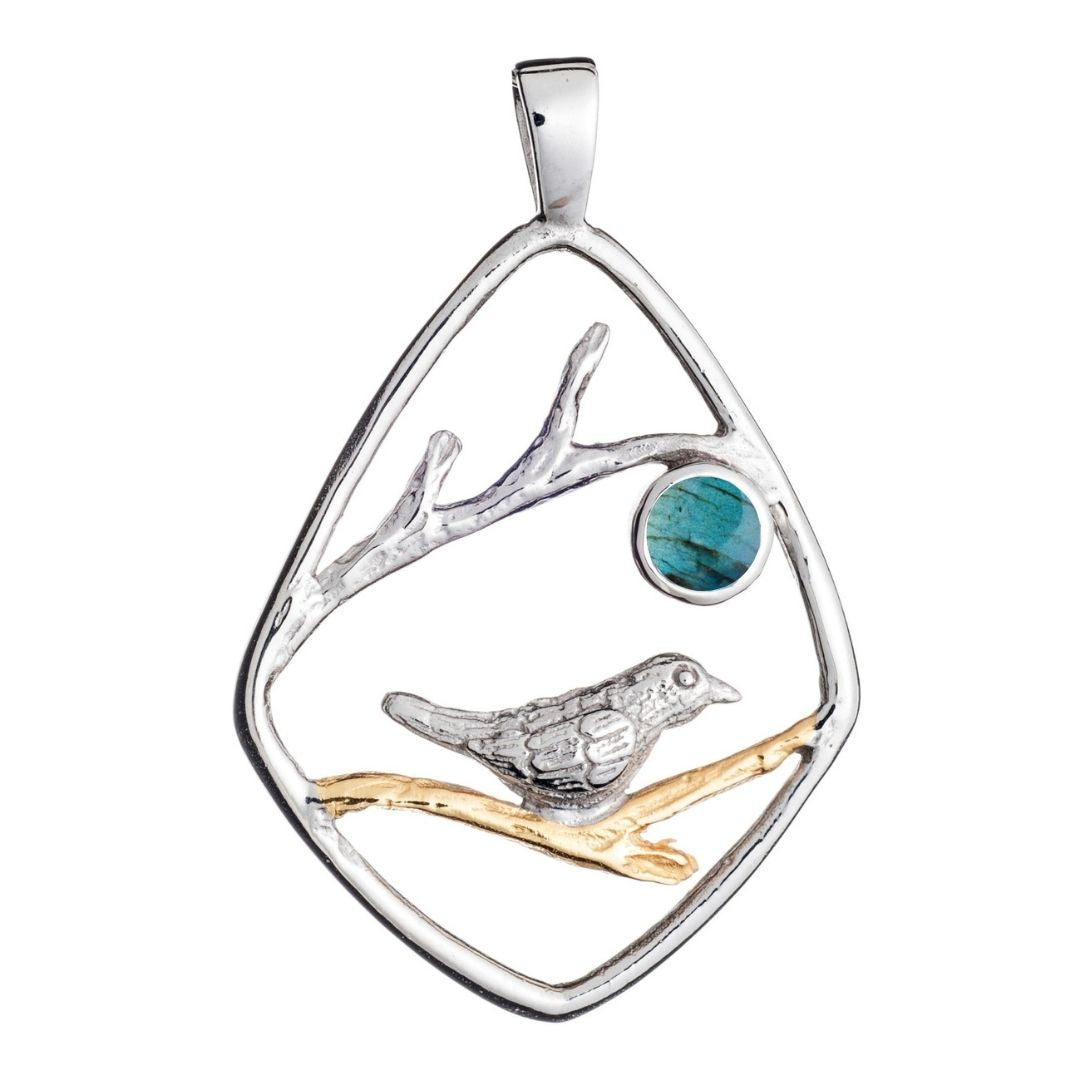 The Song Bird Pendant by Gallardo & Blaine Designs features a silver bird on a gold branch with a blue-green stone, all set in a geometric sterling silver pendant for unique nature-inspired style.
