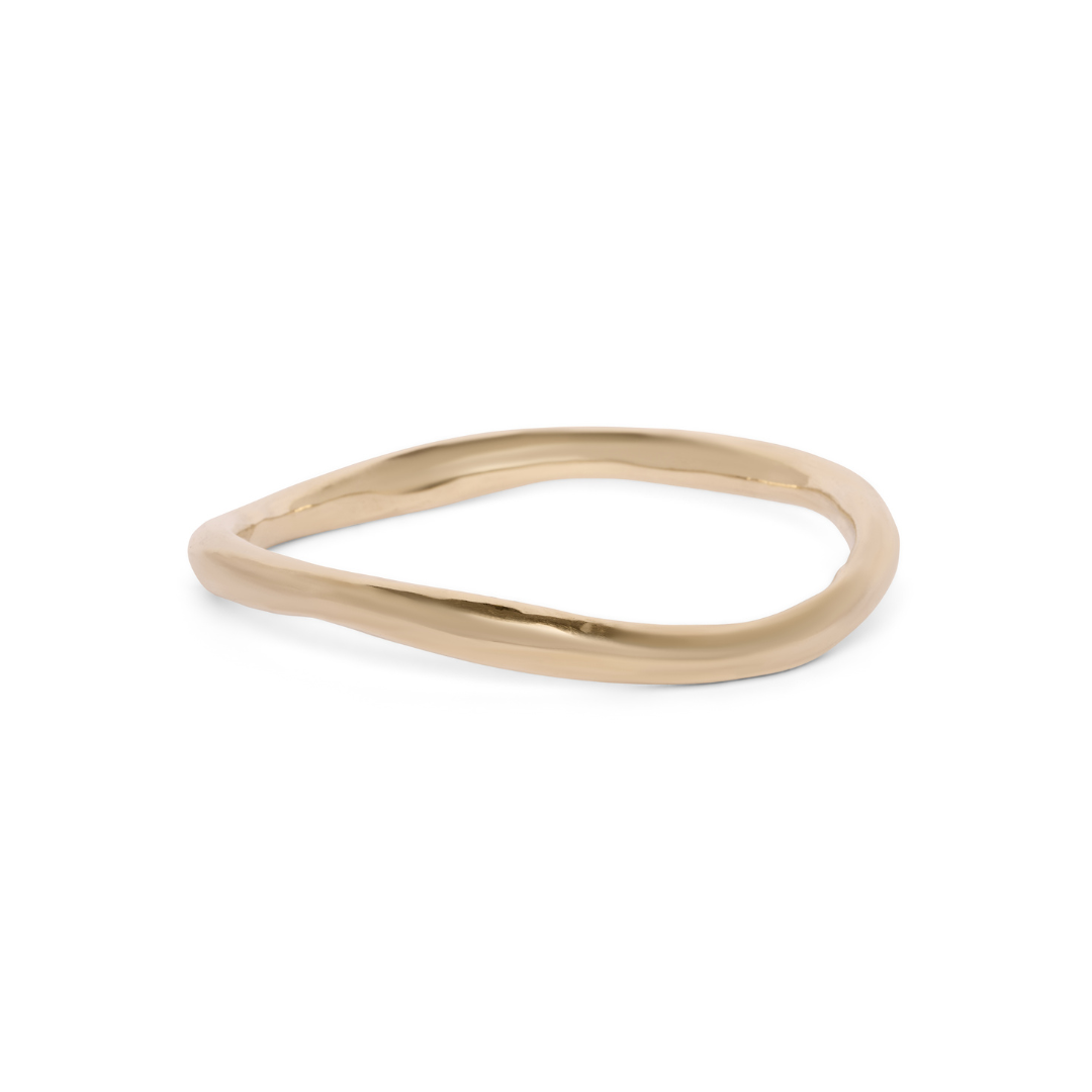 Madeleine Blaine Thorn Bangle: A thin, irregularly-shaped gold bangle with a smooth, polished surface, inspired by Dublin craftsmanship and photographed on a white background.