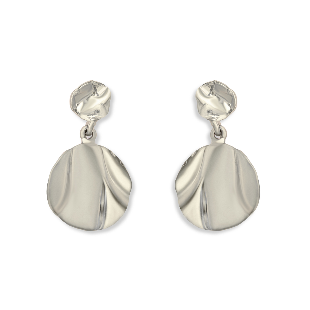 Madeleine Blaine’s Tide Drop Earrings feature abstract, organic forms inspired by classic Irish jewelry. Hand-carved in Dublin, each earring pairs a small, round top piece with a larger, uniquely shaped disc—both boasting smooth, shiny finishes with subtl
