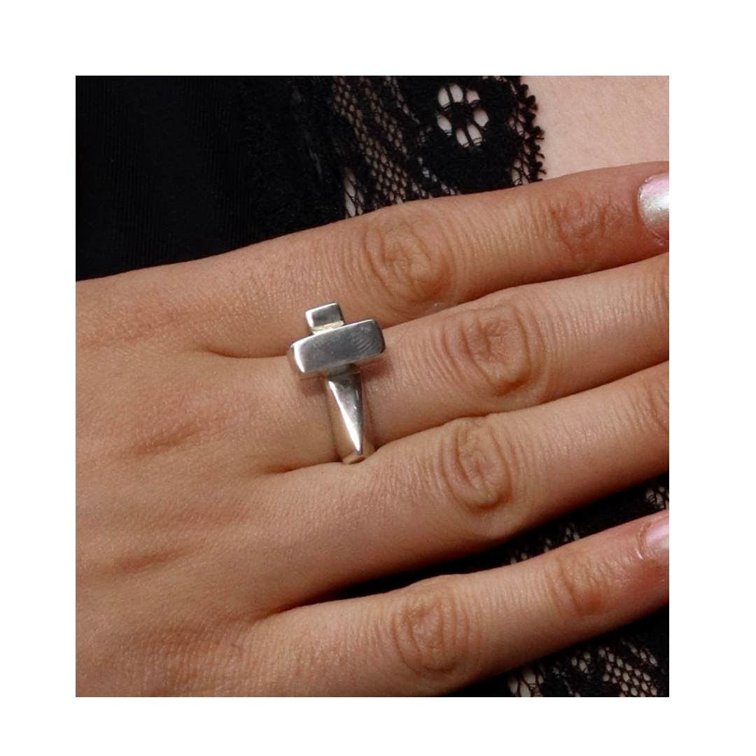 A hand with light skin wears the silver Totem Ring by Madeleine Sculptural Jewellery on the middle finger, highlighting its unique handmade design against elegant black lace.